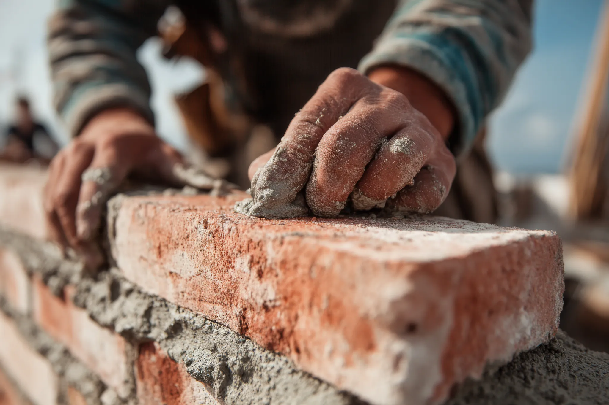 Artisan RIGORE CONSTRUCTION construisant un mur en brique